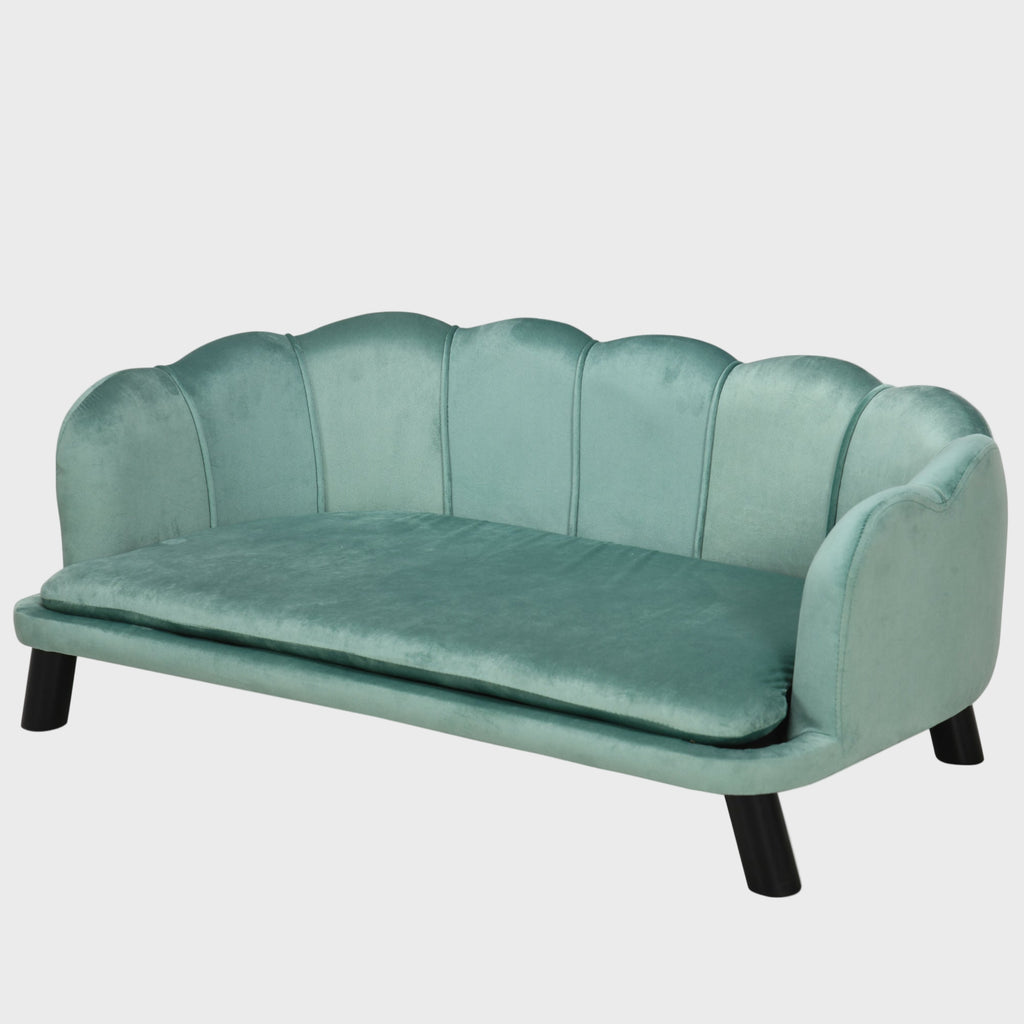 Teal velvet sofa with scalloped backrest on a white background